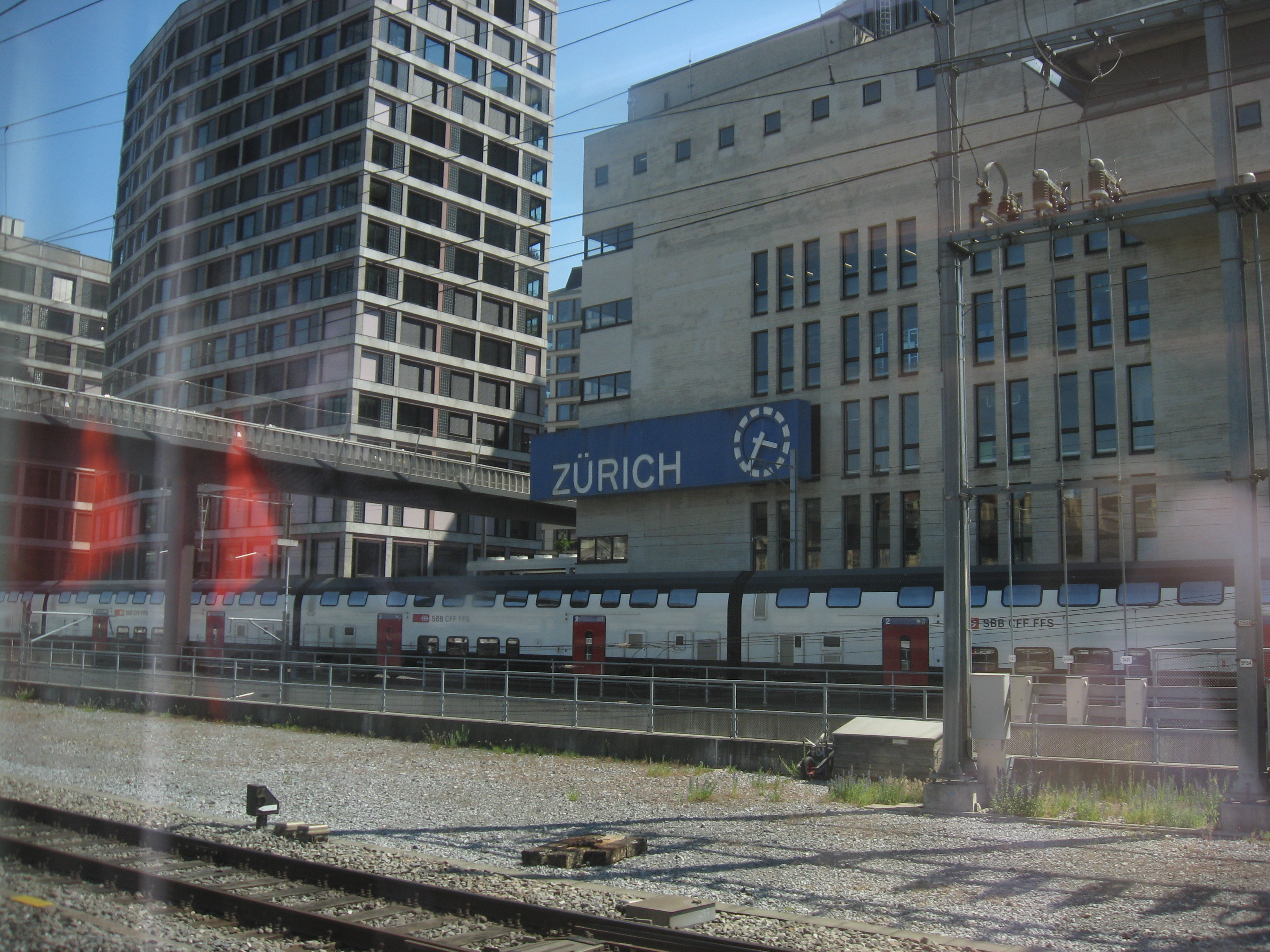 A building with a big blue sign with white text that says 'ZÜRICH'.